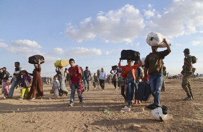 الأكراد السوريون يحملون امتعتهم بعد عبور الحدود إلى داخل الأراضي التركية 20 سبتمبر/أيلول 2014