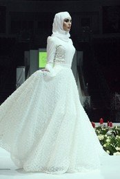 عارضة أزياء تعرض بدلة من مجموعة أبدعتها لويزا تايدايفا
