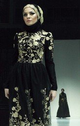 عارضة أزياء تعرض بدلة من مجموعة أبدعتها لويزا تايدايفا