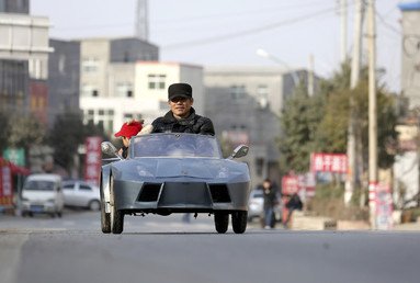 المزارع جيو الخمسيني مع حفيده يقودان سيارتهما المصنوعة يدويا كنسخة من سيارة لامبورجيني الإيطالية