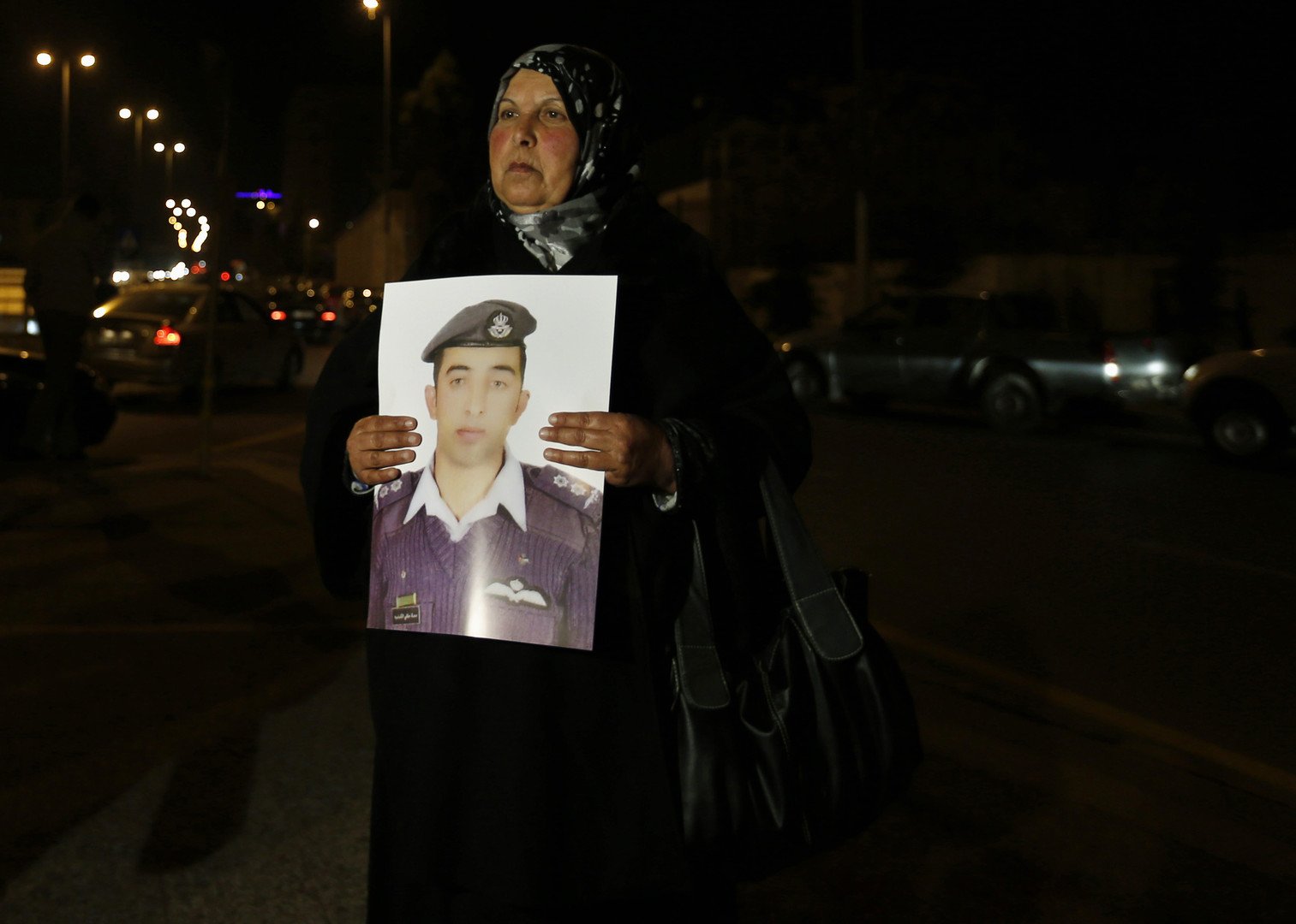 والدة الطيار معاذ تحمل صورته خلال مظاهرة لمطالبة الحكومة الأردنية بالتفاوض مع داعش، 27 يناير 2015
