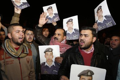 أقارب الطيار معاذ الكساسبة يحملون صورا له خلال مسيرة في مدينة الكرك، مقر أسرته، 27 يناير 2015 