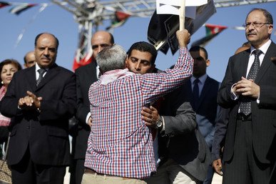 مواطن أردني يحتضن شقيق معاذ خلال مسيرة لإعلان التأييد للملك عبد الله في الحرب ضد داعش، 5 فبراير