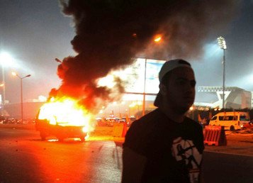 النيران تشتعل في إحدى سيارات الشرطة إثر اشتباكات قوات الأمن مع جماهير نادي الزمالك