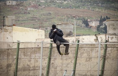 مهاجر أفريقي يحاول العبور لإسبانيا ويأكل ساندويتش ألقاه له ضباط الحراسة الإسبان، 10 فبراير 2015 