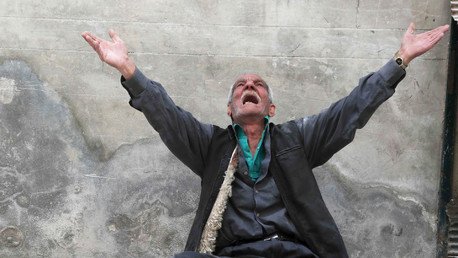 عجوز يتضرع للسماء من بين الأنقاض في حلب،أبريل 2015