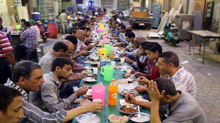 تناول وجبة الإفطار على موائد الرحمن التي تقدم مجانا خلال شهر رمضان بالقاهرة.