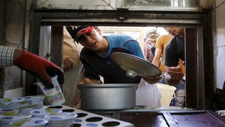  رجل يحصل على طعام مجاني يوزع للمحتاجين خلال شهر رمضان بمسجد في بغداد