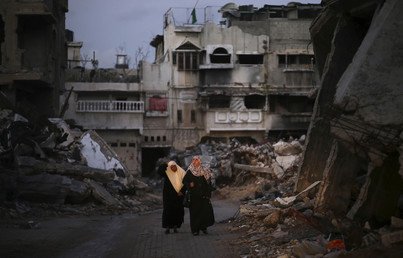 نساء فلسطينيات على أطلال ما تبقى من المنازل المدمرة، 1 ديسمبر 2014