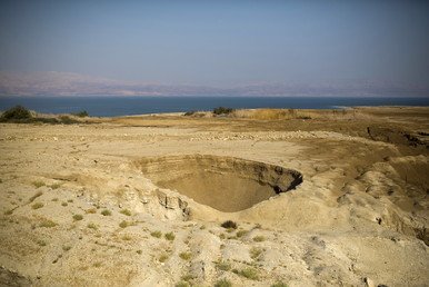صورة لأحدى الحفر الموجودة على شاطئ البحر الميت، في الجانب الإسرائيلي، 27 يوليو/تموز 2015 