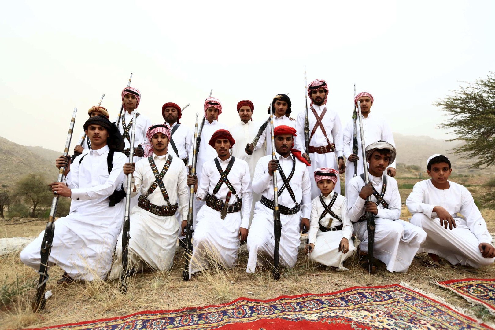  مجموعة من الأشخاص بينهم طفل يستعدون للتصوير وهم يحملون البنادق خلال أحد المناسبات بالقرب من مدينة الطائف في السعودية، 8 أغسطس 2015