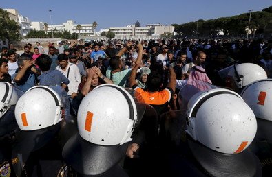 شرطة جزيرة كوس اليونانية تقف في مواجهة حشود اللاجئين السوريين في استاد الجزيرة الوطني، 11 أغسطس 2015 