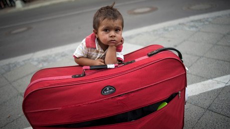 صبي من اللاجئين ينتظر عند حقيبة والديه خروجهما من مديرية الشؤون الصحية والإجتماعية في برلين