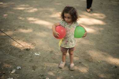 طفلة صغيرة من اللاجئين تلعب بالكرات في أثناء انتظارها والديها اللذين ذهبا إلى مديرية الشؤون الصحية والاجتماعية في برلين لطلب اللجوء في ألمانيا