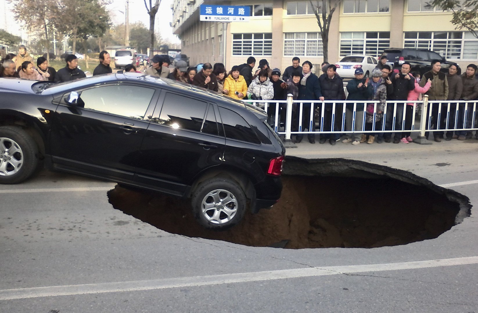 سيارة معلقة على شفى حفرة انهارت في الطريق في مقاطعة جيانغسو الصينية