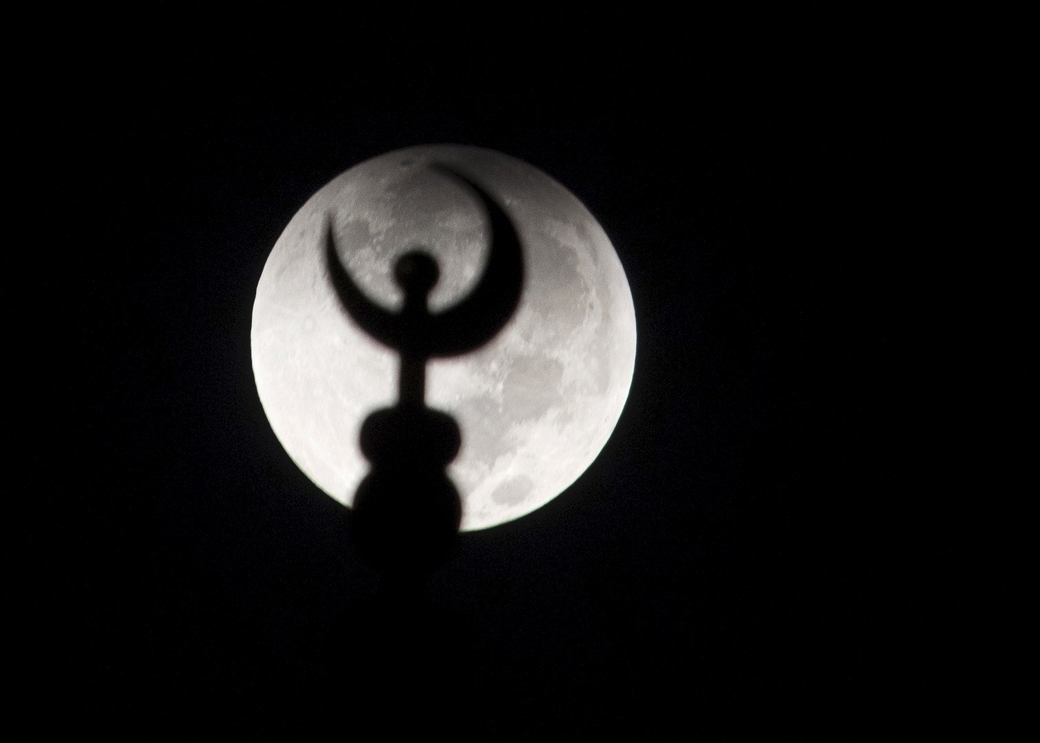 مشهد للقمر العملاق قبل بداية الخسوف، خلف مئذنة مسجد في مدينة الكويت، الكويت، 28 سبتمبر/أيلول 2015 