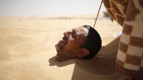 شاب يدفن نفسه في الرمال الساخنة في سيوة طلبا للعلاج، مصر، 12 أغسطس/آب 2015