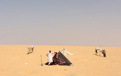 عامل ينتظر بالقرب من خيمة بعد تحضير الحفر وتركيب خيام "ساونا" للمستجمين في سيوة، مصر، 11 أغسطس 2015