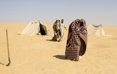 مستجمون يضعون أغطية بعد العلاج بحمام الرمال الساخنة في سيوة، مصر، 12 أغسطس 2015