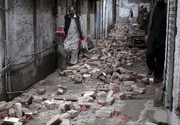  باكستانيون يسيرون بين حطام منازلهم جراء الزلزال العنيف 26 أكتوبر/تشرين الأول 2015 