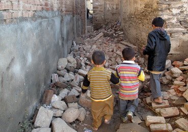  أطفال يسيرون بين حطام الزلزال العنيف أمام منازلهم في باكستان (27 أكتوبر/تشرين الأول 2015)