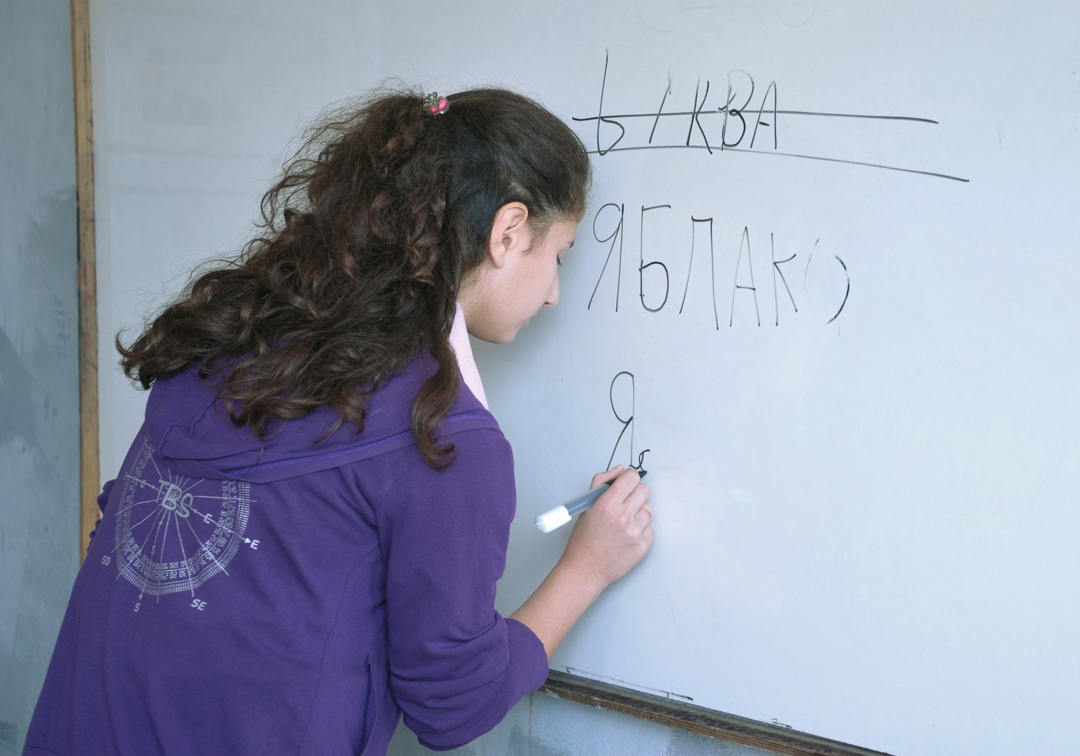 طالبة في الصف السابع  بمدرسة سهيل أبو الشملات تكتب كلمات روسية على اللوح