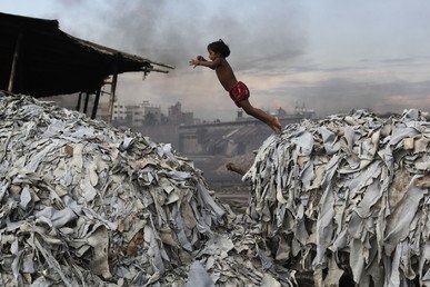طفلة تنط بين أكوام الفضلات المستخدمة لإعداد علف للدجاج في مدبغة للجلود في بنغلاديش