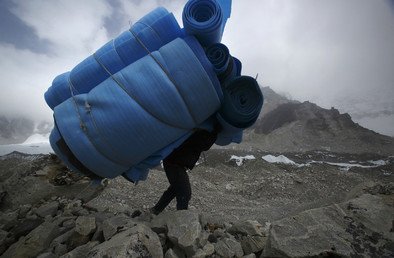 حمّال ينقل فُرُشاً من من معسكر لمتسلقي جبل إفرست حتى ارتفاع 5300 متر فوق سطح البحر