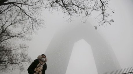 امرأة صينية تمر بجانب مبنى محطة التلفزيون المركزي الصيني