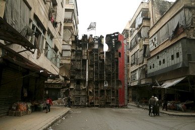 3 شاحنات موضوعة بشكل عمودي لحماية المارة من نيران القناصة في أحد أحياء المدن السورية