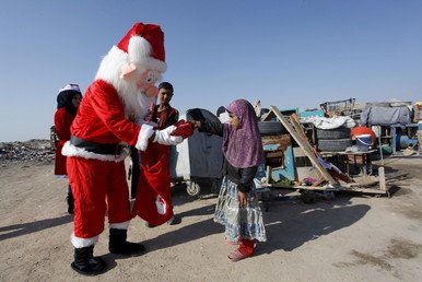 متطوع ارتدى أزياء بابا نويل يسلم هدايا إلى أطفال 