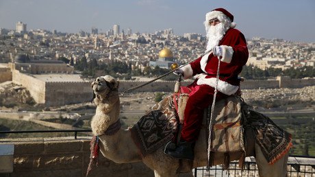 فلسطيني من أبناء 48 يمتطي جملا ويرتدي زي سانتا كلوز خلال مهرجان شجرة الكريسمس السنوي، في جبل الزيتون بالقدس المحتلة يوم 21 ديسمبر/كانون الأول 2015