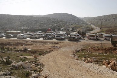 مقاتلون من تحالف لجماعات متمردة تدعى "جيش حركة فتح"، المعروف أيضا باسم "جيش الفتح"، يرافقون سيارات إسعاف الهلال الأحمر العربي السوري وحافلات إجلاء المقاتلين والمدنيين من اثنتين من البلدات المحاصرة، الفوعة وكفريا في ريف إدلب، للعبور إلى تركيا من معبر الحدود السورية التركية المسمى باب الهوى.