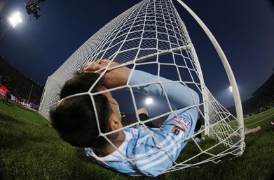 الأرجنتيني ليونيل ميسي يقع داخل الشباك أثناء المباراة النهائية لكأس كوبا أمريكا 2015 ضد تشيلي في الملعب الوطني في سانتياغو، تشيلي، 4 يوليو/تموز 2015.
