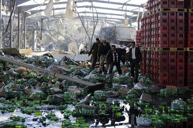مسؤولون يتفقدون الأضرار في مصنع المشروبات كوكا كولا، بعد أن دمرته غارة جوية للتحالف في صنعاء، اليمن