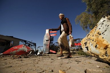 حارس يمشي في مصنع المشروبات كوكا كولا، بعد أن دمرته الغارات الجوية، التي شنتها التحالف في صنعاء