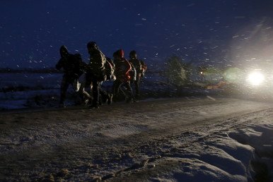 مهاجرون يمشون في طريق بعد عبورهم الحدود المقدونية
