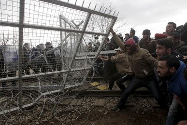 لاجئون عالقون يحاولون تحطيم الأسوار على الحدود المقدونية - اليونانية خلال الاحتجاجات التي قاموا بها اعتراضا على عدم السماح لهم بمواصلة طريقهم نحو الشمال الأوروبي، بالقرب من بلدة إيدوميني اليوانانية، 29 فبراير/شباط 2016 