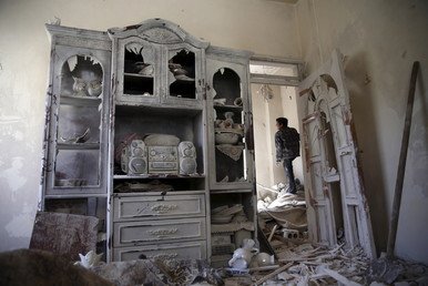 ولد يتفحص منزلا مدمرا في دوما