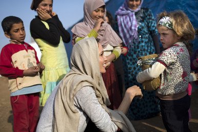 الممثلة انجلينا جولي تبتسم عند لقائها اللاجئين السوريين في وادي البقاع عام 2014 خلال أدائها مهمة إنسانية في لبنان.