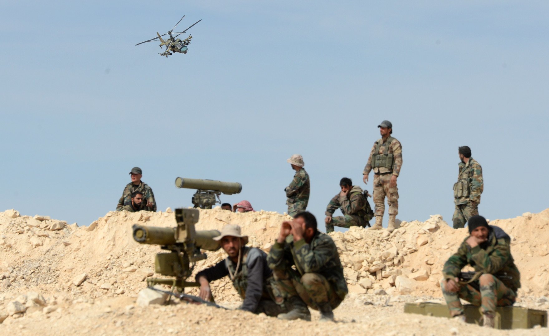  جنود من الجيش السوري ومروحية "التمساح" Ka -52 في أثناء العمليات القتالية في محيط مدينة القريتين التي تم تحريرها من براثن المسلحين.