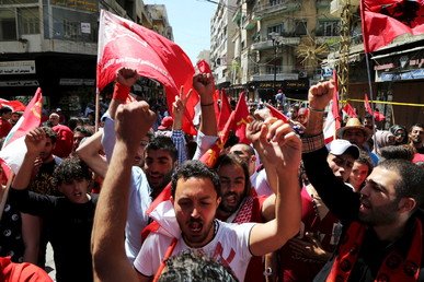 متظاهرون يحملون أعلاما حمراء في أثناء مسيرة نظمها الحزب الشيوعي اللبناني