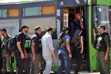 مقاتلو المعارضة يصعدون إلى الحافلة لإخلاء المدينة