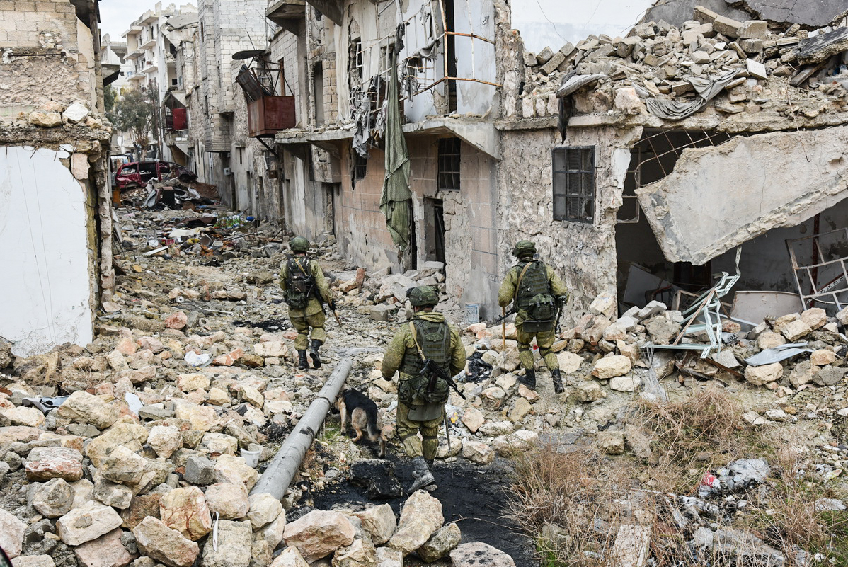 خبراء روس برفقة كلاب مدربة يتفقدون حيا شبه مدمر في حلب الشرقية