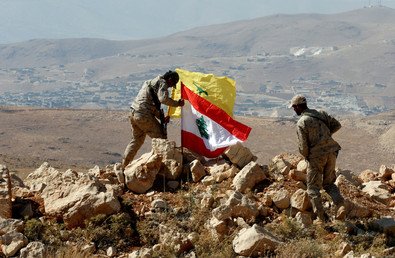 مقاتلو حزب الله يرفعون علم لبنان وعلم حزب الله في جرود عرسال، على الحدود السورية اللبنانية. 25 يوليو 2017
