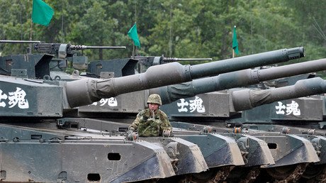 أحد عناصر قوات الدفاع اليابانية يقف بجانب دبابة "T90" خلال التدريبات المشتركة مع سلاح البحرية الأمريكي في منطقة هوكودايين في إنيوا. 14 أغسطس 2017