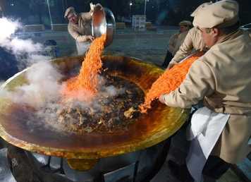 طهاة خلال اعداد أكبر طبق بيلاو (أو بيلاف) على طريقة دوشنبه ، خلال مهرجان "أوشي بالاف" في حديقة "فردافسي"في دوشنبه، طاجكستان