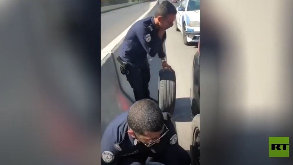 شرطة الكويت تستبدل إطار سيارة متوقفة على جانب الطريق