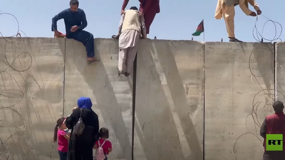 الأفغان يتسلقون جدارا للوصول إلى مدرج مطار حامد كرزاي الدولي