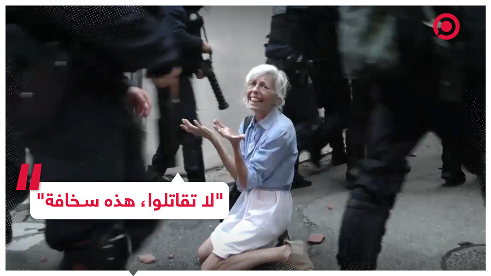 سيدة فرنسية تجثو على ركبتيها مطالبة الشرطة بوقف العنف